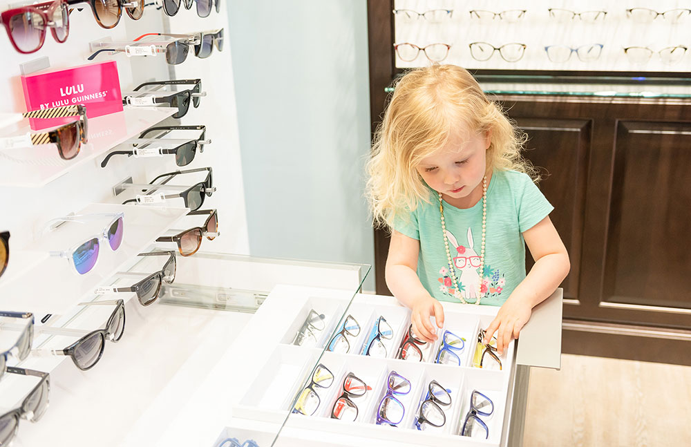 Girl child pediatric looking at eyeglasses at Wauseon Eye Care